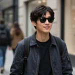 A person wearing stylish Ray-Ban Meta smart glasses on a busy city street